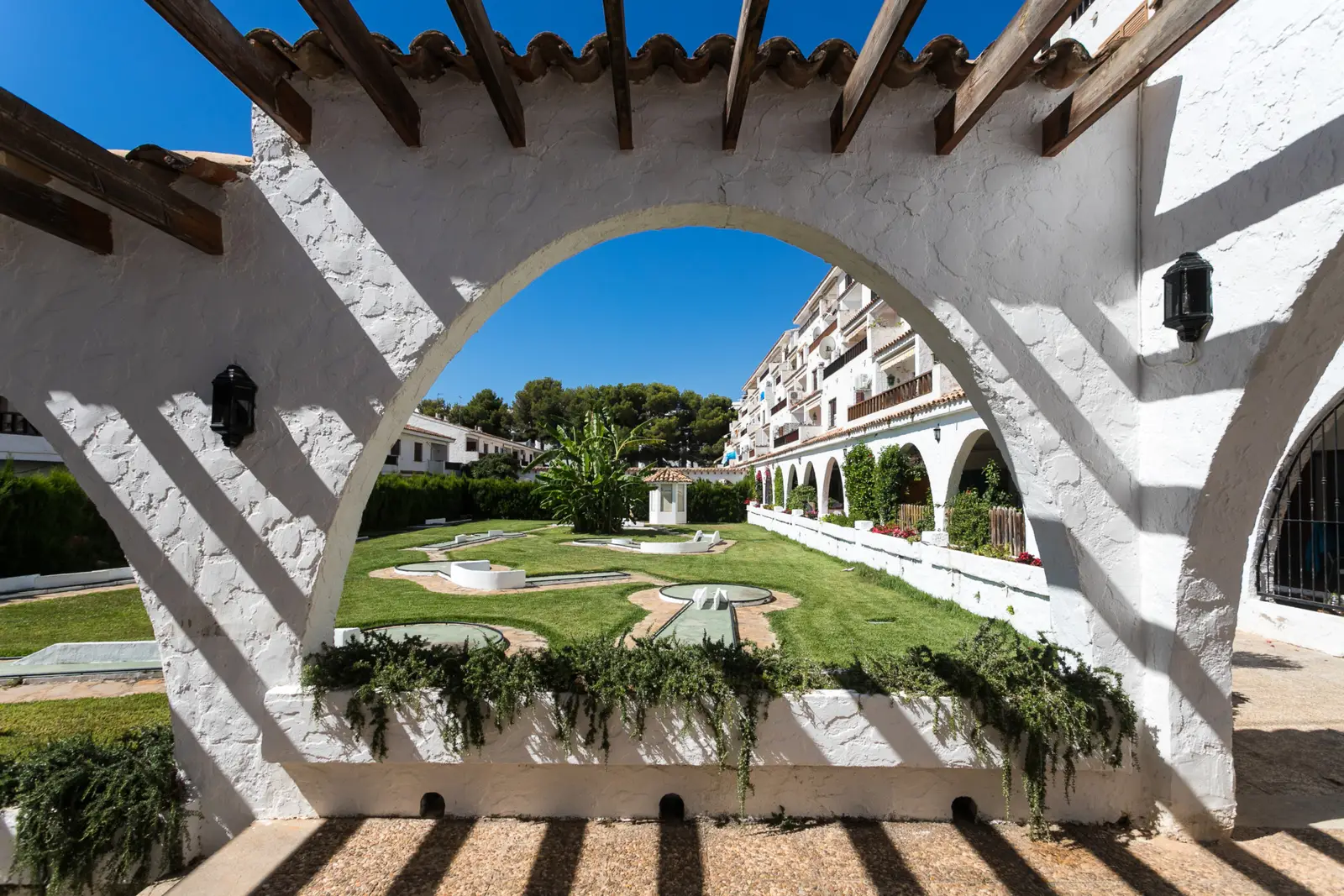 Arcades blanches et jardin de la résidence Arcos I à Las Fuentes, Alcossebre